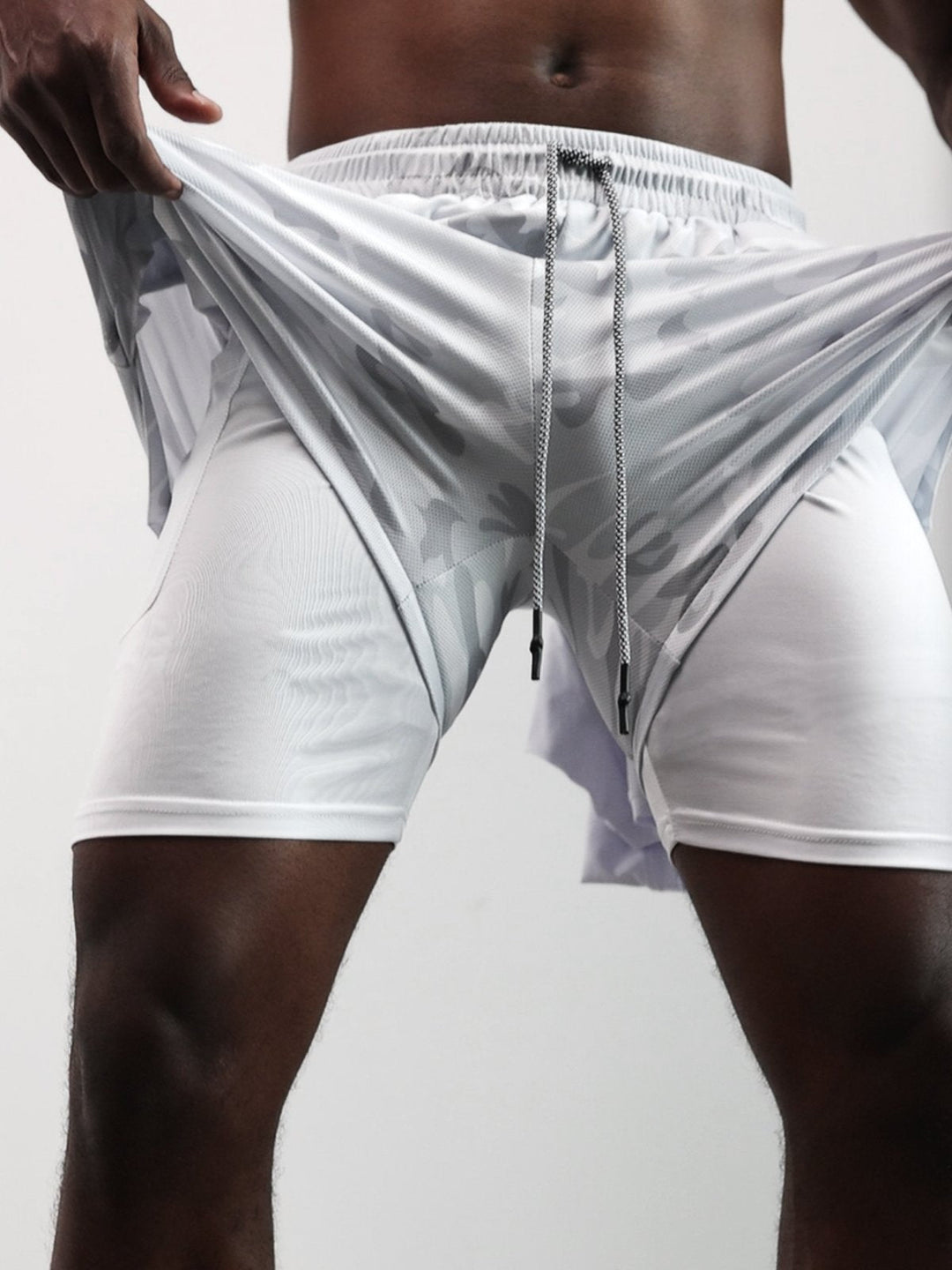Detail of elastic waistband on men's Kinetic mesh shorts, ensuring secure workout fit.