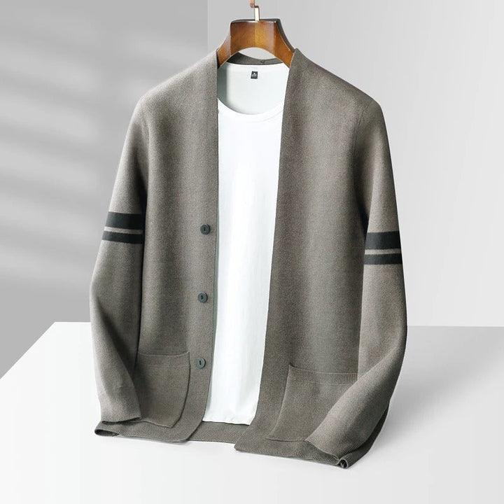 Detail shot of a men's modern knit cardigan with distinctive patch pockets and soft knitwear.