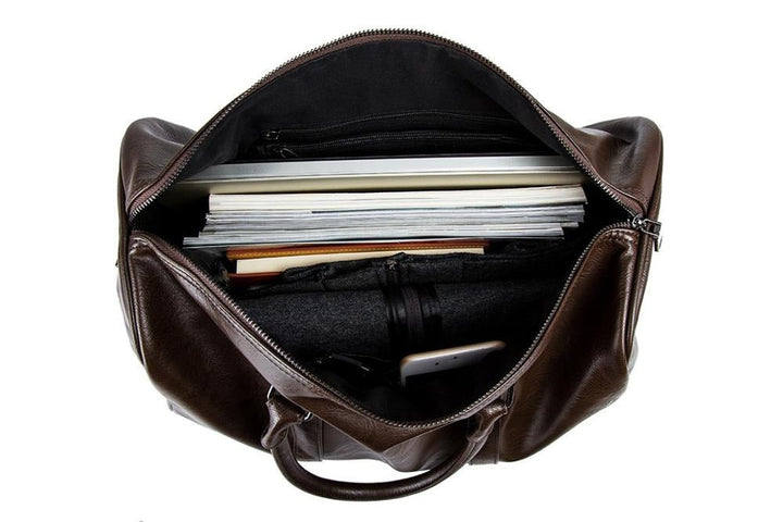 Detailed view of sturdy zippers on a men's leather duffel, lightweight travel carry-on.