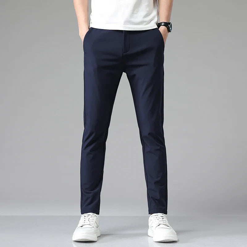 Detail shot: waistband and closure of men's modern straight fit performance pants. Tailored design.