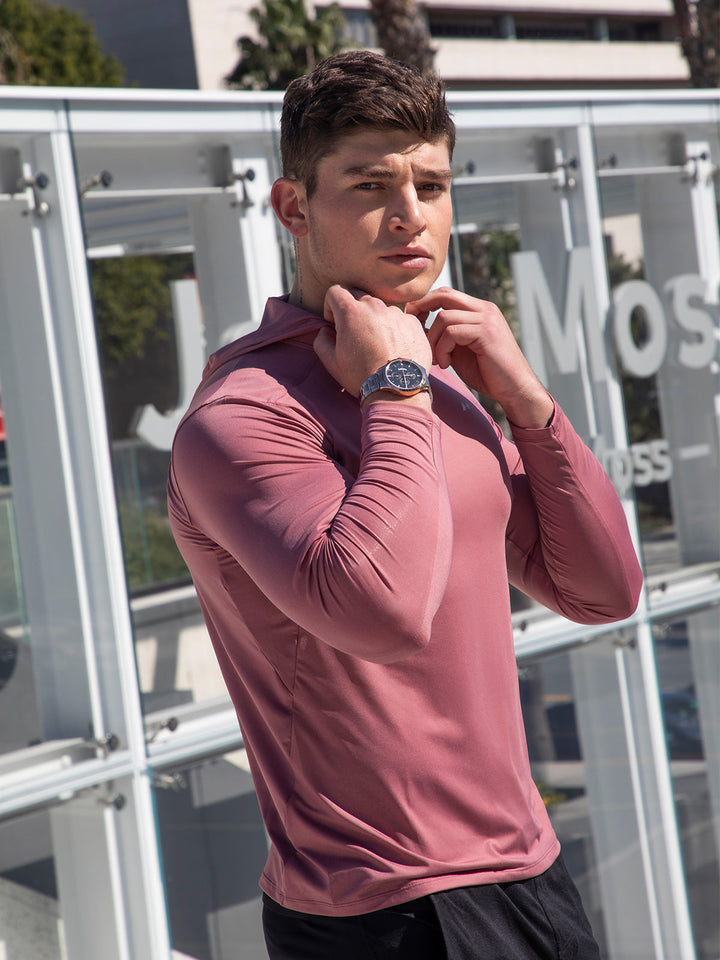 Man in men's performance baselayer hoodie, running outdoors; moisture-wicking, stretch fit for active comfort.