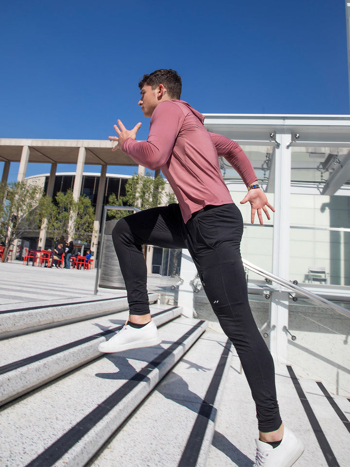 Athlete training in men's performance baselayer hoodie; stretch fit, moisture-wicking for comfort.