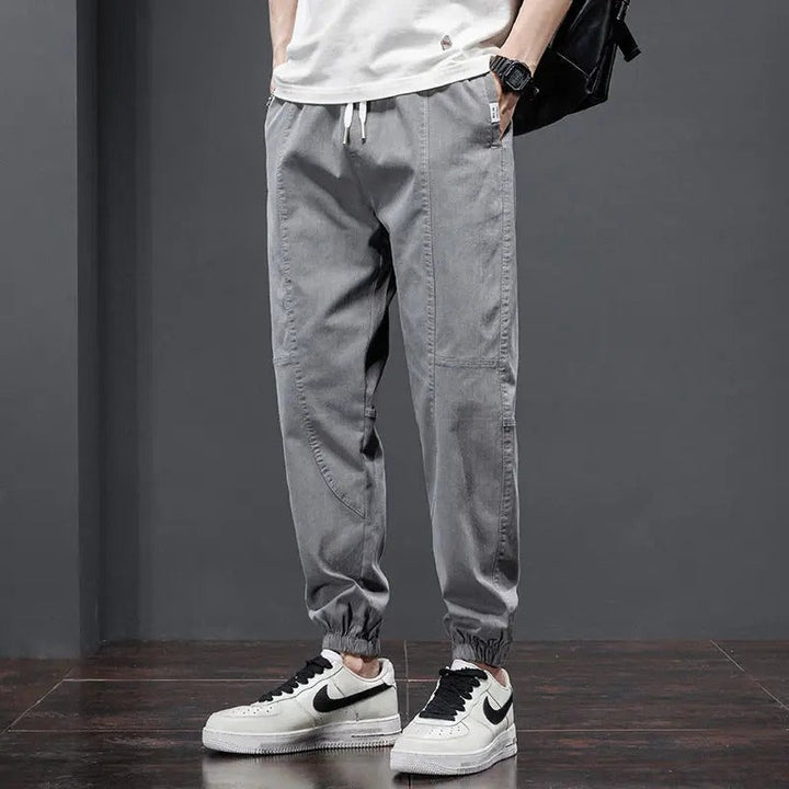 Man in gray relaxed fit tapered leg joggers, showcasing activewear comfort and modern casual style.