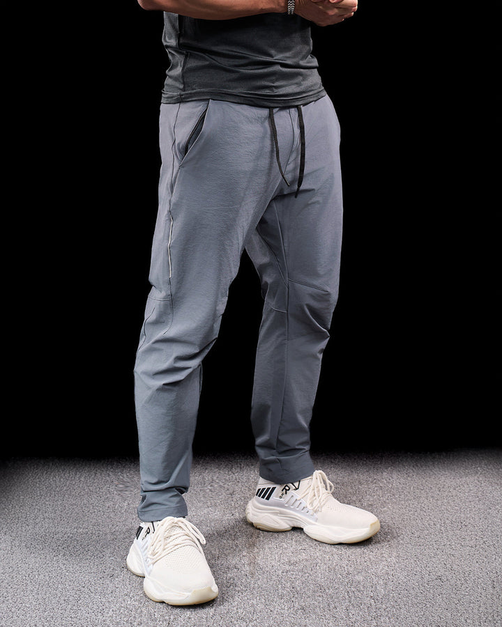 Men's stretch adventure pants in action while hiking. Durable, flexible outdoor activewear for trails.