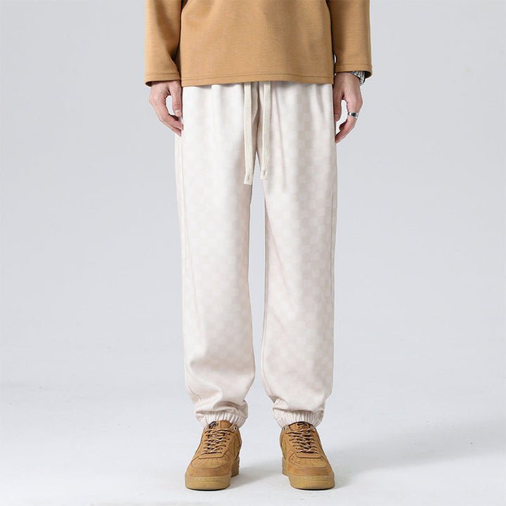 Distinctive checkerboard pattern on men's relaxed-fit sweatpants, a stylish choice for any casual look.