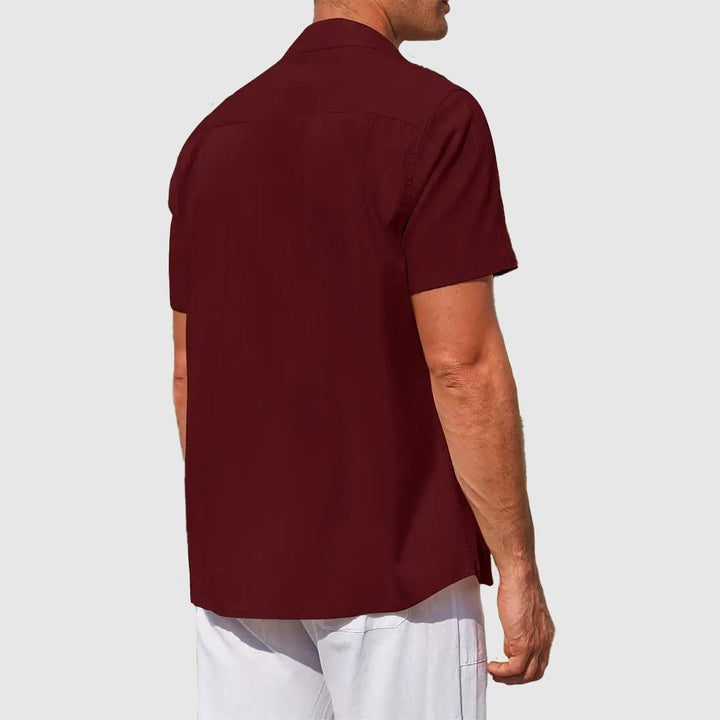 Detailed view of a men's textured short sleeve top, highlighting fabric weave and button closure.