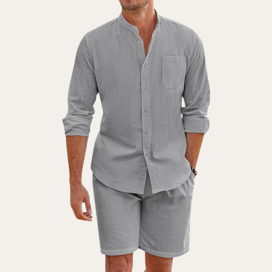 Man wearing a stylish two-piece summer set: long sleeve shirt & shorts, enjoying a beach vacation.