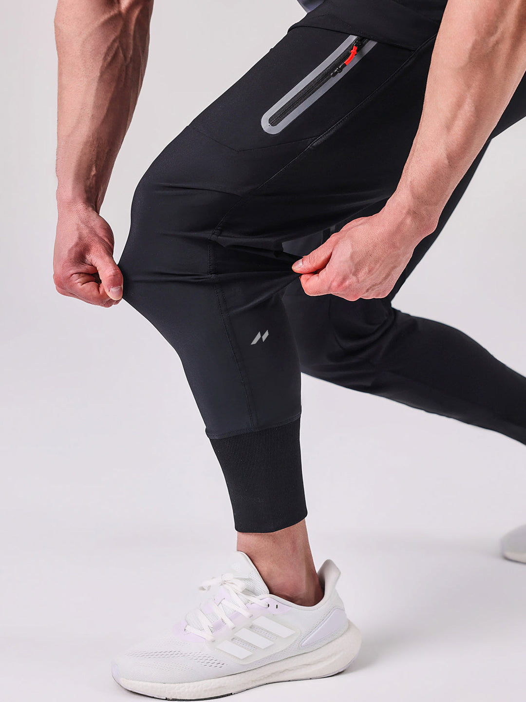 Detail shot: Utility pocket on men's cargo joggers, black, emphasizing practical design.