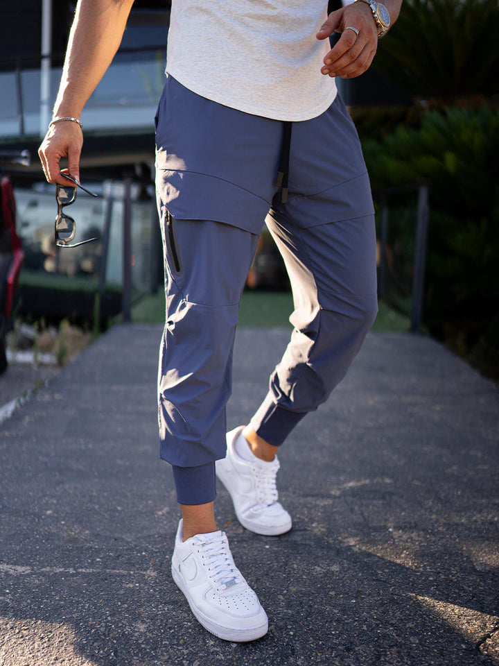 Man walking in men's streetwear cargo joggers in urban setting, highlighting versatile style.