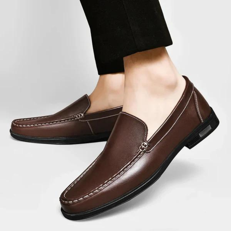 "Mocassini uomo in vera pelle italiana, dettagli cuciti a mano, eleganti e moderni, visione laterale a colori neutri."
