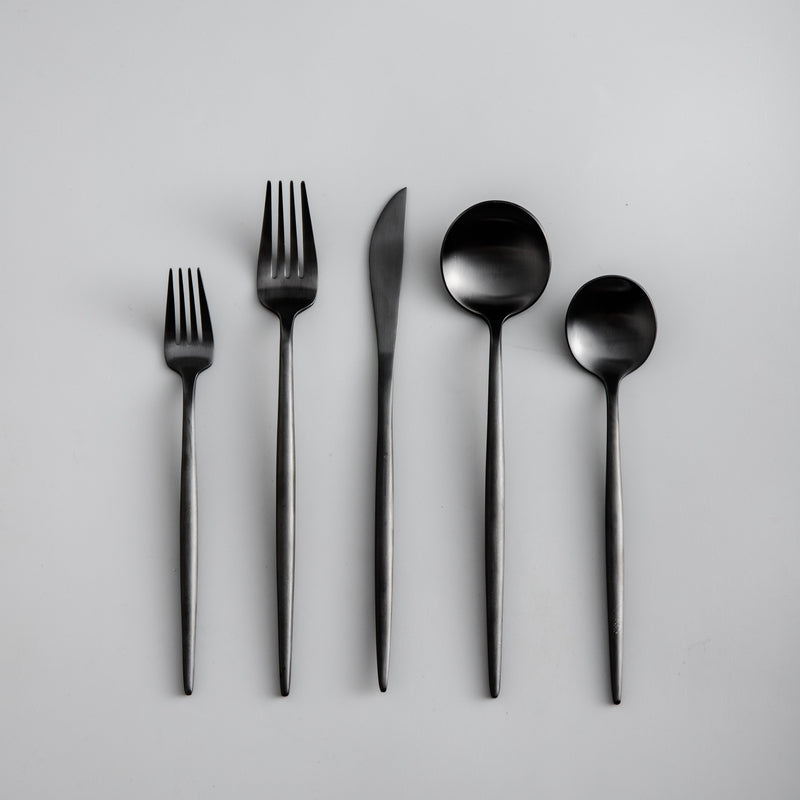 Close-up of a sleek matte black dinner knife from a modern cutlery set.
