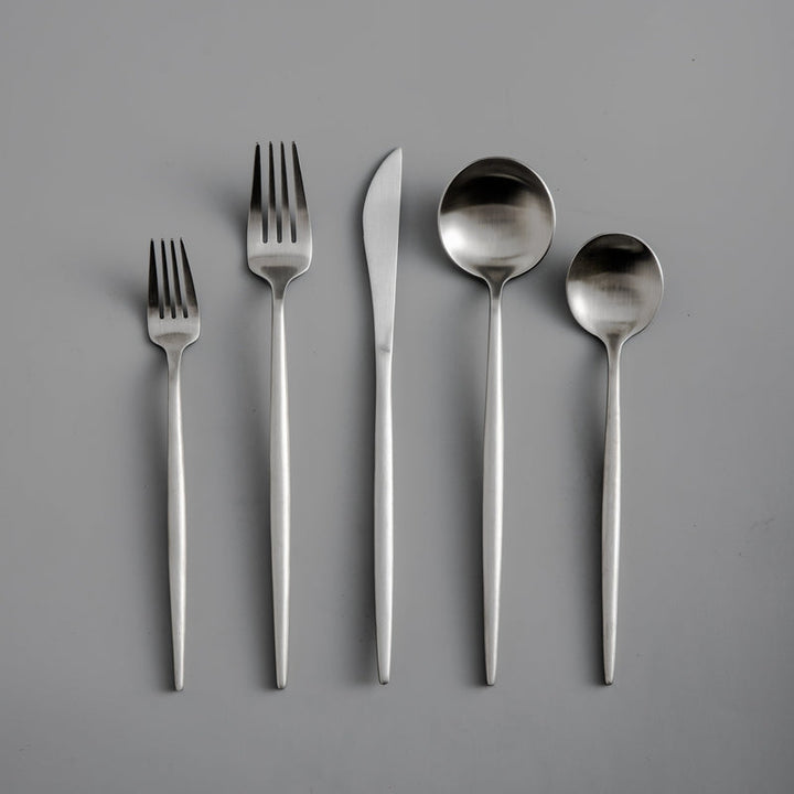 Modern dining experience with a matte gold flatware set, minimalist design.