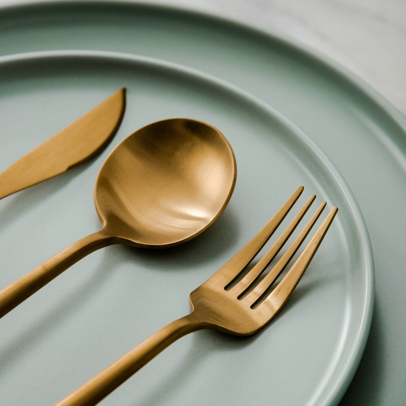 Close-up of a matte silver minimalist dinner fork, part of a modern dining set.