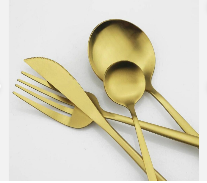 Full view of a sophisticated matte gold flatware set for an elegant table setting.