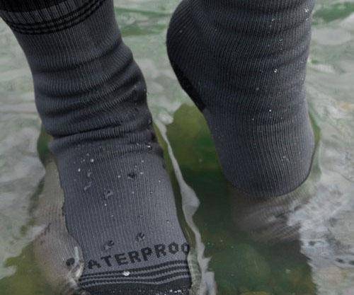 Close-up of waterproof trekking socks, black, showing breathable fabric texture.