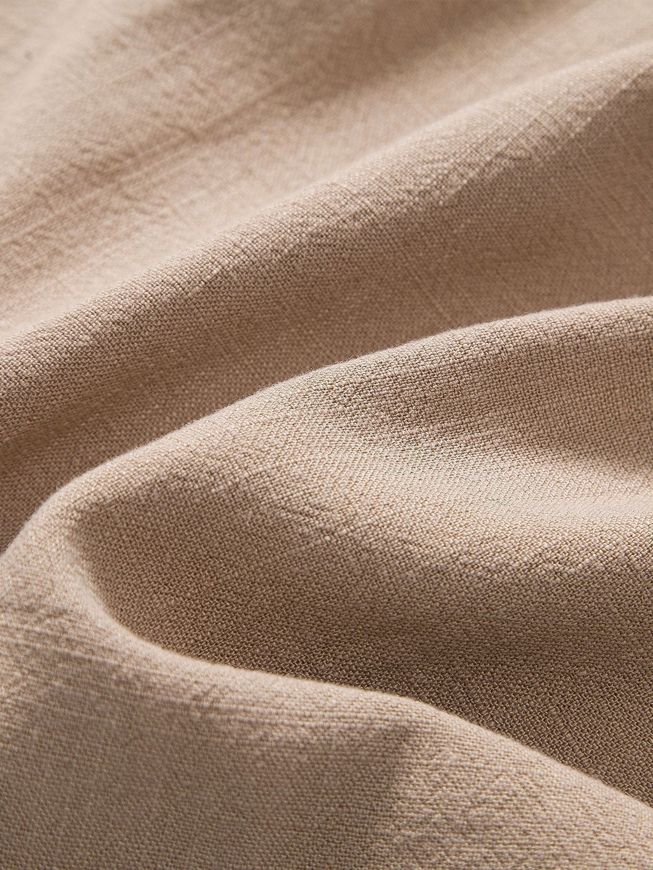 Polo beige di lino con pantaloni slim-fit, look elegante e moderno per uomo, abbigliamento estivo traspirante e chic.