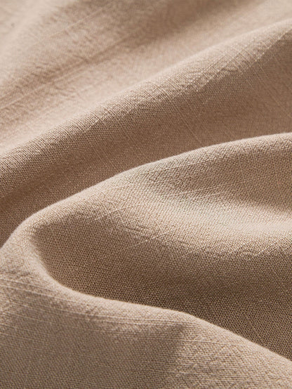Polo beige di lino con pantaloni slim-fit, look elegante e moderno per uomo, abbigliamento estivo traspirante e chic.
