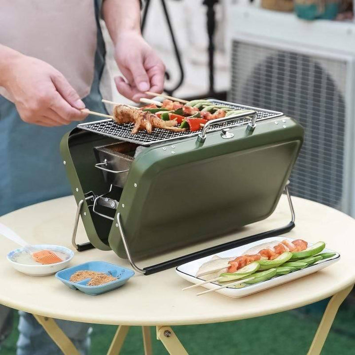 Portable charcoal grill showing compact folded design, ready for travel and outdoor cooking