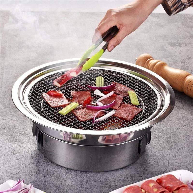Portable stainless steel charcoal BBQ grill for outdoor camping and picnic cooking, compact design.