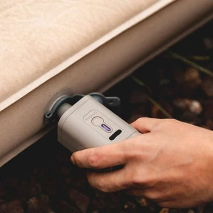 Compact USB mini air pump with an integrated light, ideal for inflating air mattresses and camping gear.