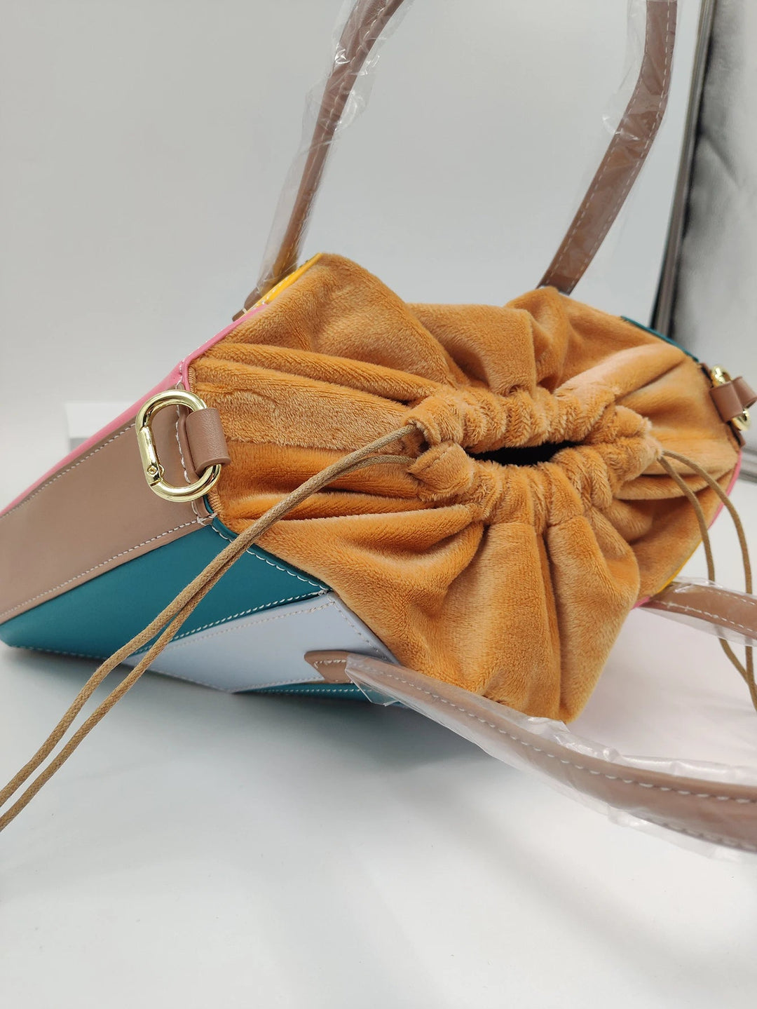 Modern women's top handle sculptural bag. Luxurious vegan leather with a radiant geometric design, perfect for any outfit.