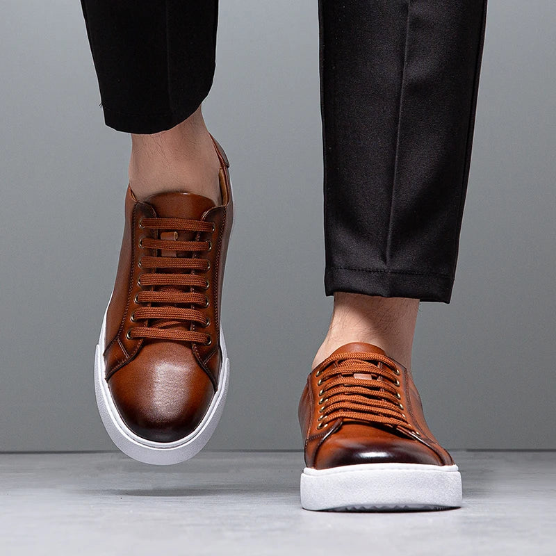 Sneakers eleganti in pelle da uomo, colore marrone, design sobrio, suola bianca, perfette per look casual e semi-formali.