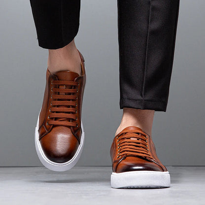 Sneakers eleganti in pelle da uomo, colore marrone, design sobrio, suola bianca, perfette per look casual e semi-formali.