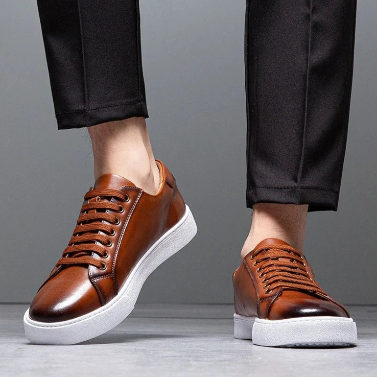 Sneakers eleganti in pelle da uomo, colore marrone, design sobrio, suola bianca, perfette per look casual e semi-formali.