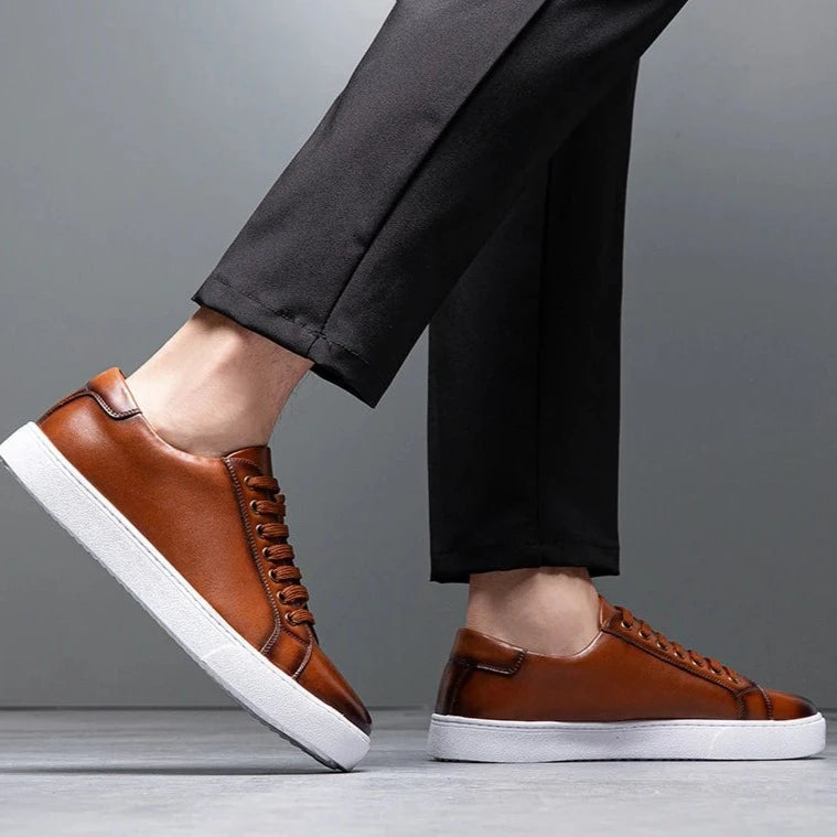 Sneakers eleganti in pelle da uomo, colore marrone, design sobrio, suola bianca, perfette per look casual e semi-formali.
