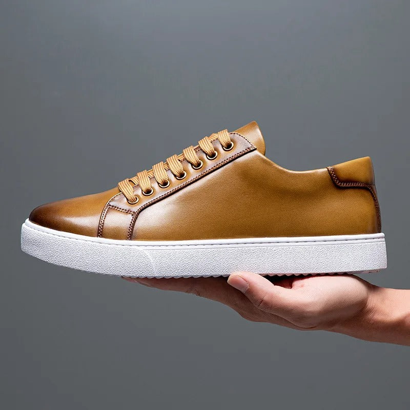 Sneakers eleganti in pelle da uomo, colore marrone, design sobrio, suola bianca, perfette per look casual e semi-formali.
