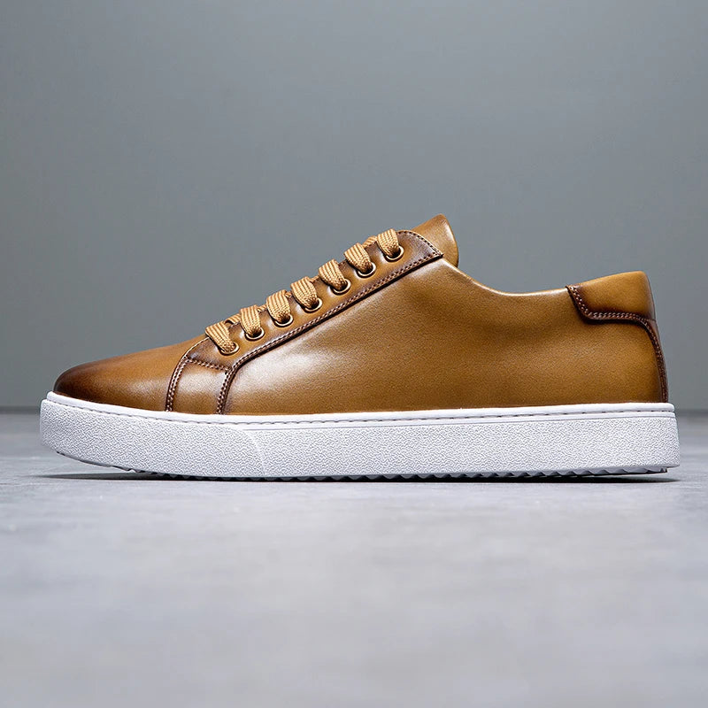 Sneakers eleganti in pelle da uomo, colore marrone, design sobrio, suola bianca, perfette per look casual e semi-formali.