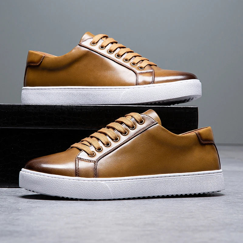 Sneakers eleganti in pelle da uomo, colore marrone, design sobrio, suola bianca, perfette per look casual e semi-formali.