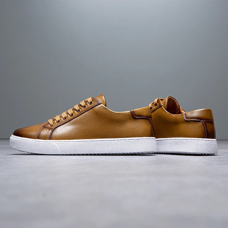 Sneakers eleganti in pelle da uomo, colore marrone, design sobrio, suola bianca, perfette per look casual e semi-formali.