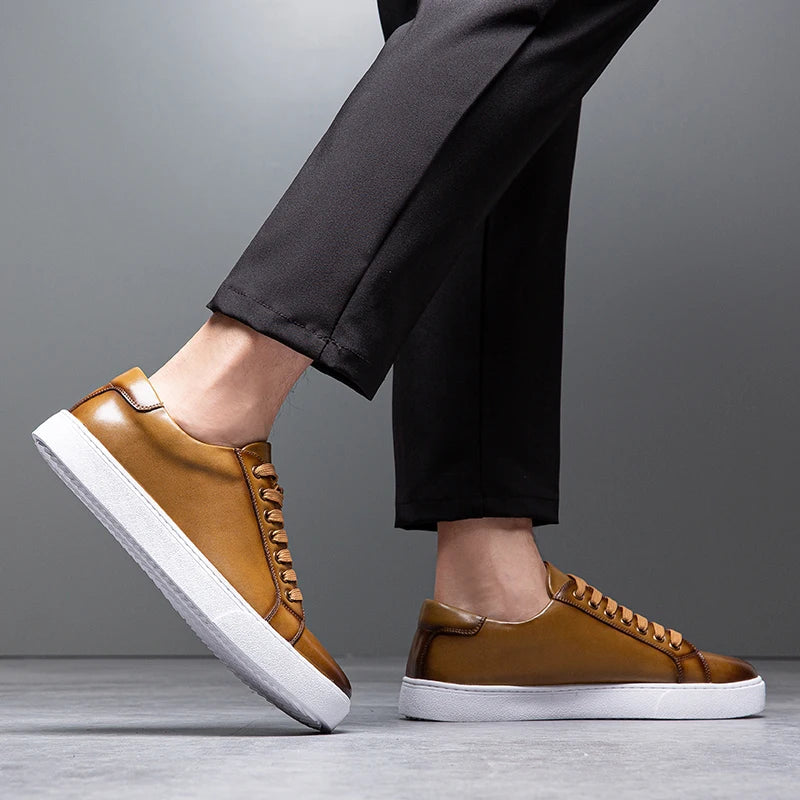 Sneakers eleganti in pelle da uomo, colore marrone, design sobrio, suola bianca, perfette per look casual e semi-formali.