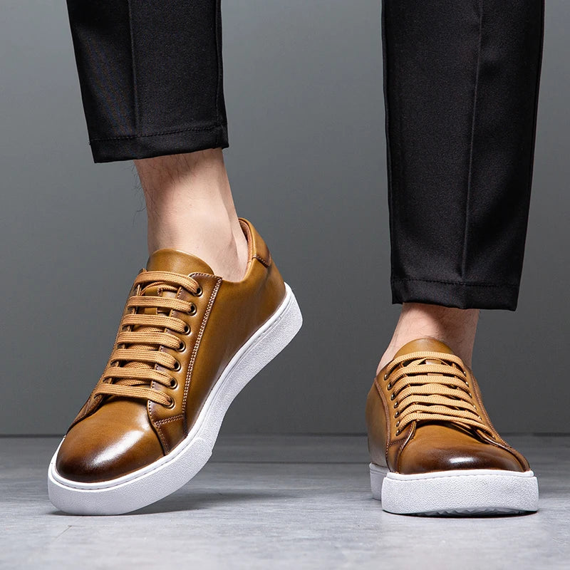 Sneakers eleganti in pelle da uomo, colore marrone, design sobrio, suola bianca, perfette per look casual e semi-formali.
