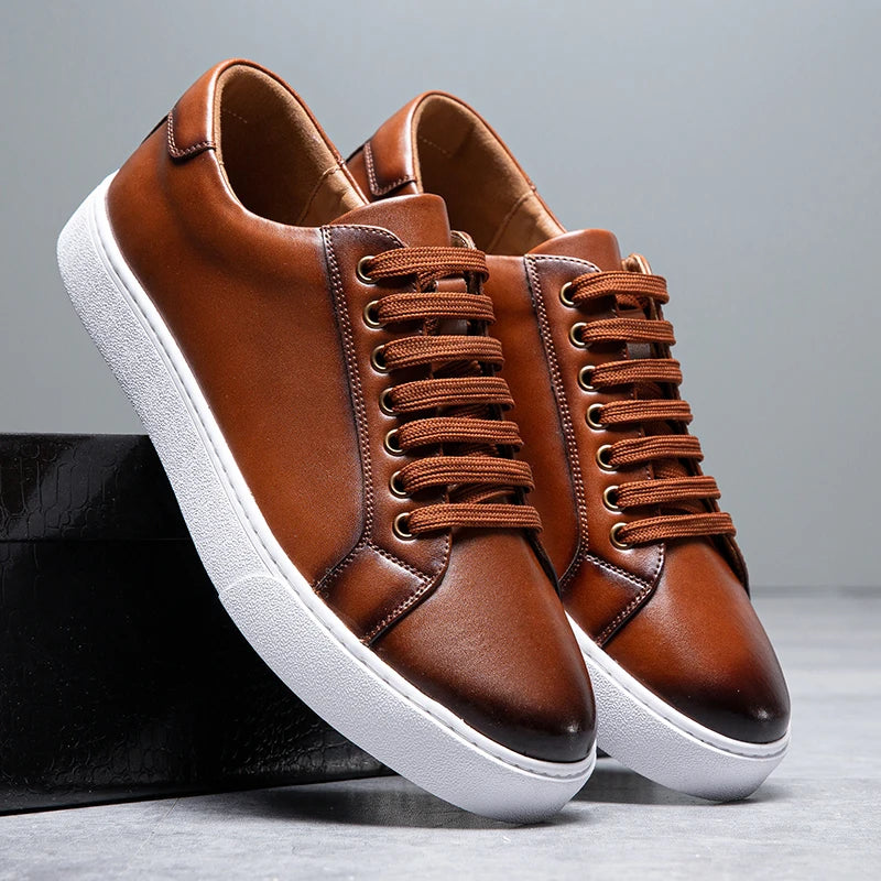 Sneakers eleganti in pelle da uomo, colore marrone, design sobrio, suola bianca, perfette per look casual e semi-formali.