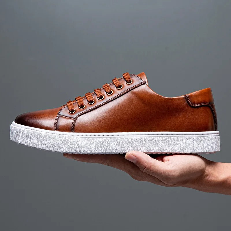 Sneakers eleganti in pelle da uomo, colore marrone, design sobrio, suola bianca, perfette per look casual e semi-formali.