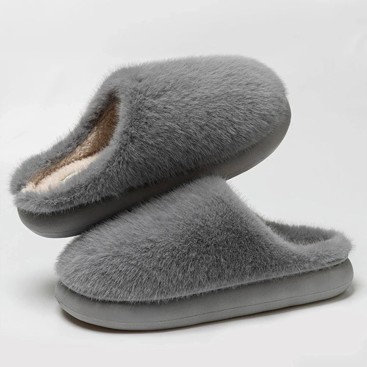 Durable sole on soft blue plush women's slippers, cozy indoor footwear for superior home comfort.