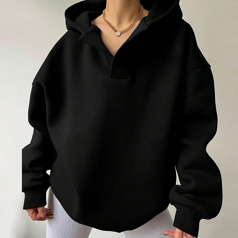 Woman models a relaxed fit, cozy women's oversized V-neck pullover hoodie, ideal for stylish casual wear.