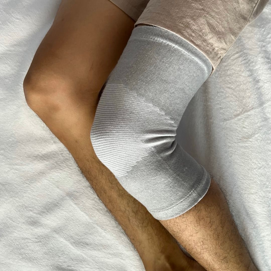 "Supporto ginocchio unisex nero, fascia regolabile e traspirante per comfort e stabilità, dettagli moderni e discreti."