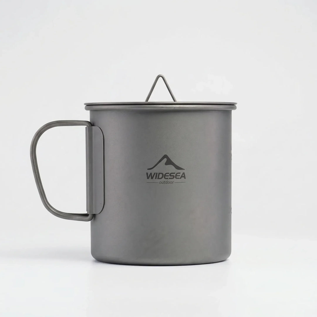 Compact titanium camping mug with foldable handle, essential outdoor cooking and travel gear.