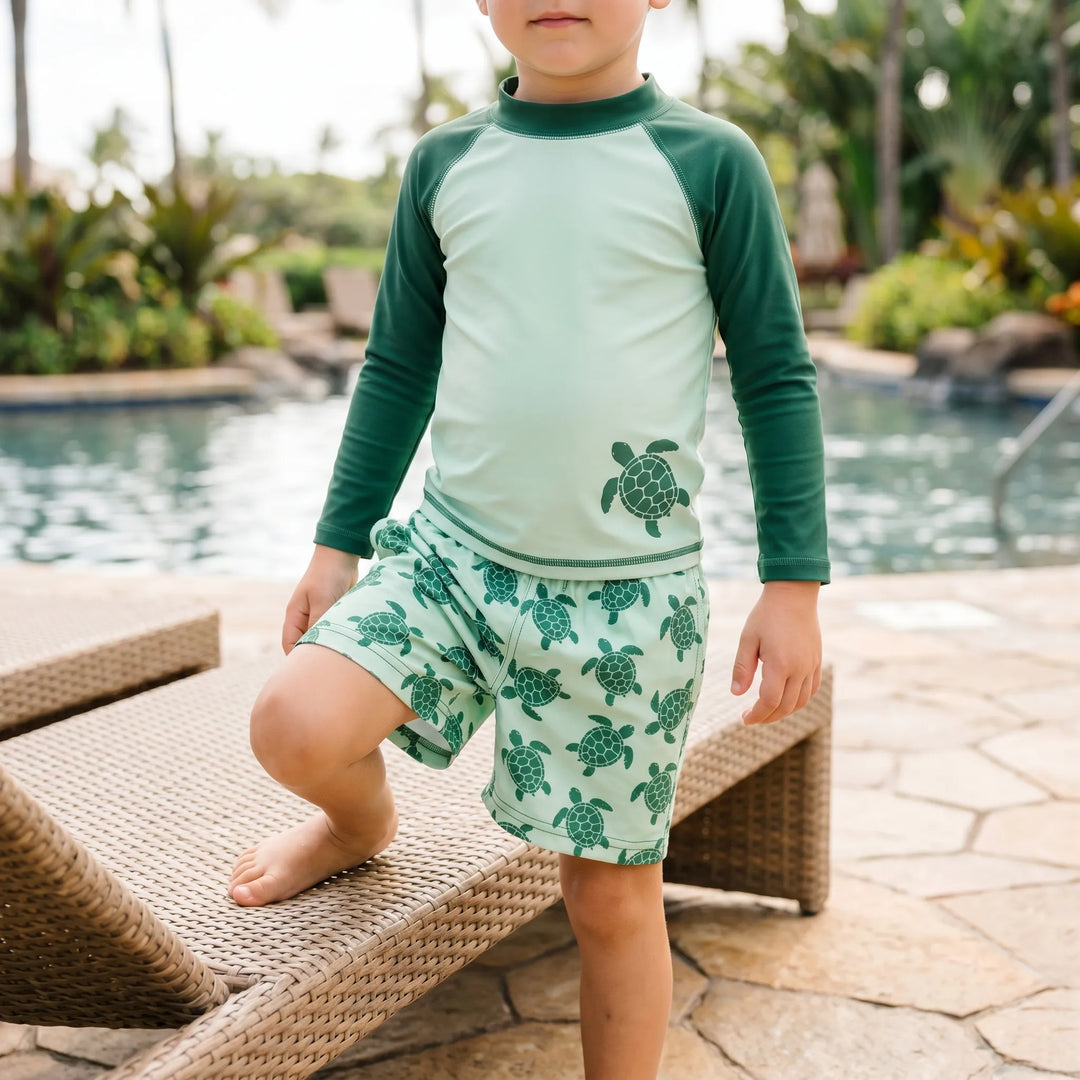 Toddler girl's long-sleeve rash guard swim set with playful tortoise print for sun protection.