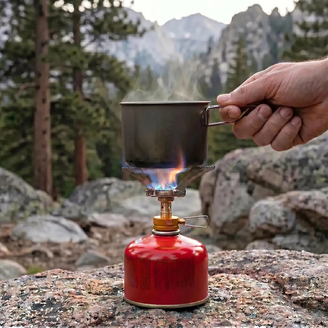 Lightweight folding backpacking stove, compact gas burner for hiking, camping, and essential survival gear.