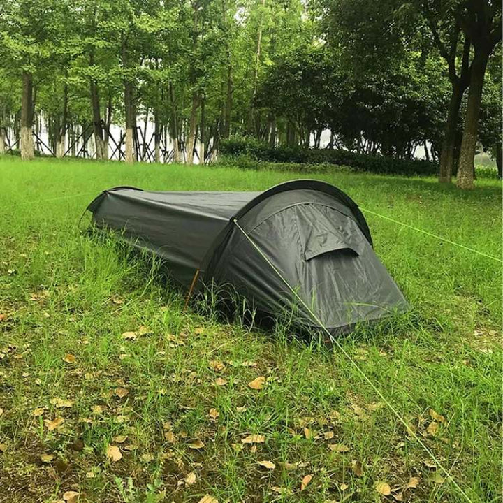 Ultralight single person backpacking tent, green, packed in a compression sack, ready for hiking