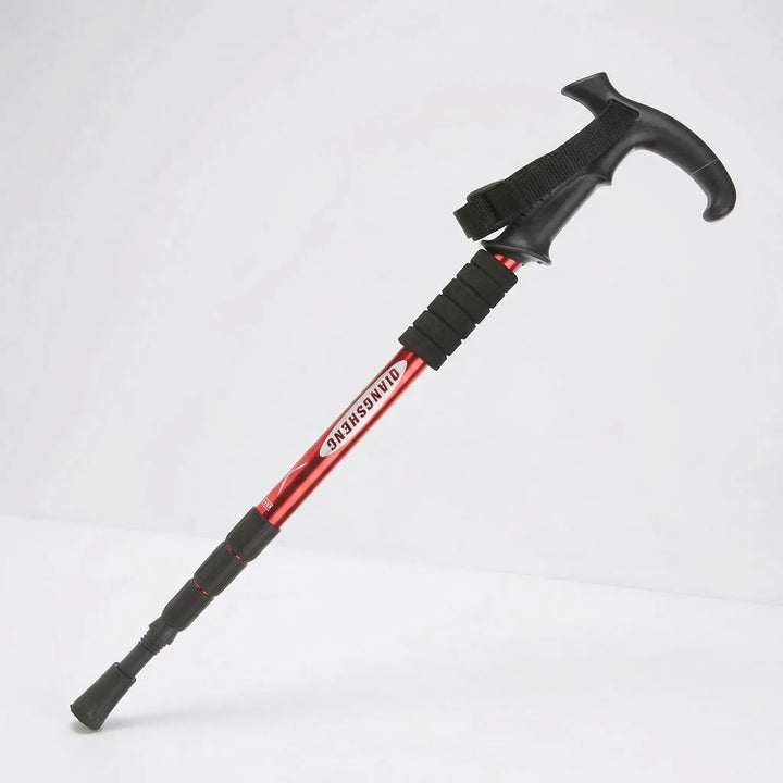 Hiker using a 4-section folding trekking pole for stability on a challenging mountain trail.
