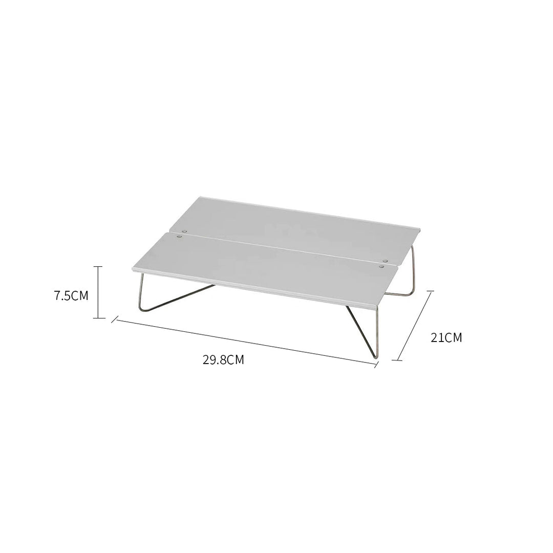 Lightweight aluminum outdoor table, pictured in a natural setting, perfect for picnics and hiking.