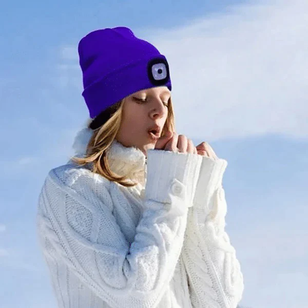 Detail of the removable LED light unit from a black beanie, emphasizing its rechargeable feature.
