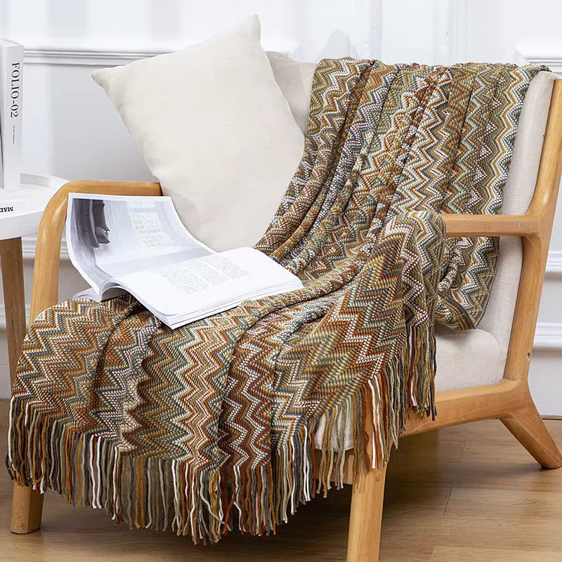 Earthy-toned boho striped throw blanket with playful tassels, a cozy home accent.