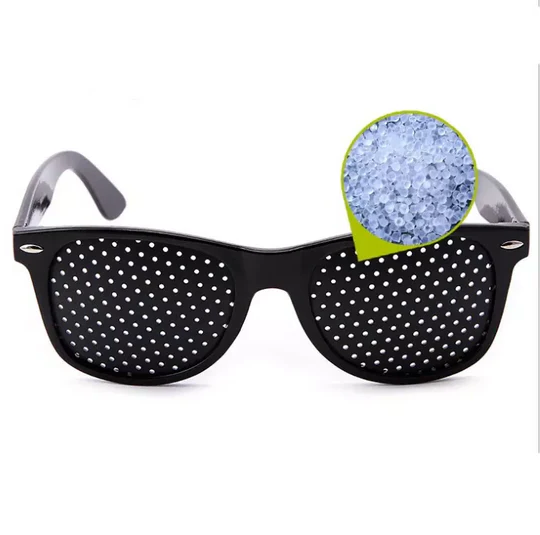 Close-up of black pinhole glasses designed for natural vision correction, improving focus and relieving eye strain.