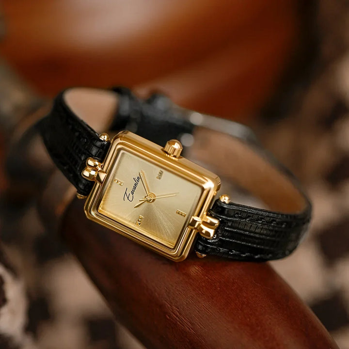Close-up of a stylish unisex watch with a shining gold face & classic faux leather strap. Timeless fashion.